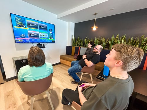 Four people sitting in front of a TV screen.