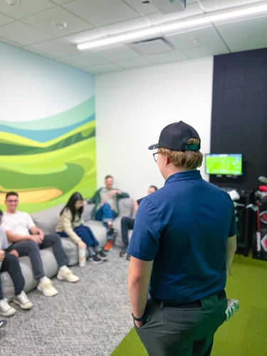 Golf pro providing an introduction to a group of people.