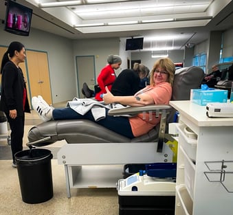 A Payworks staff giving the thumbs up while donating blood. 