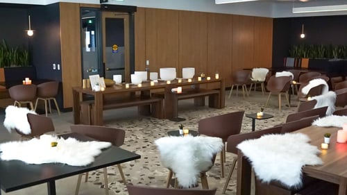 A cozy atmosphere setup with candles, blankets and chairs.