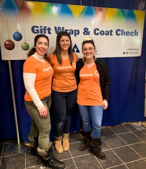 Three Payworks staff in Pay it Forward t-shirts.