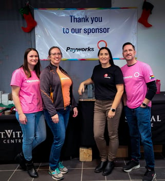 Four Payworks staff standing by a "Thank you to our sponsor" sign. 
