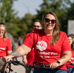 Trois membres du personnel de Payworks marchent à côté d’un vélo. 