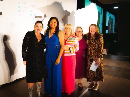Payworks Co-Founder Barb Gamey on stage with four award-winners. 