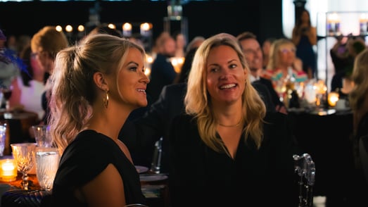 Two Payworks staff in conversation during a gala dinner. 