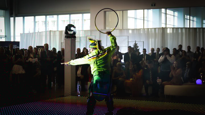 An Indigenous hoop dancer performing for a large crowd. 