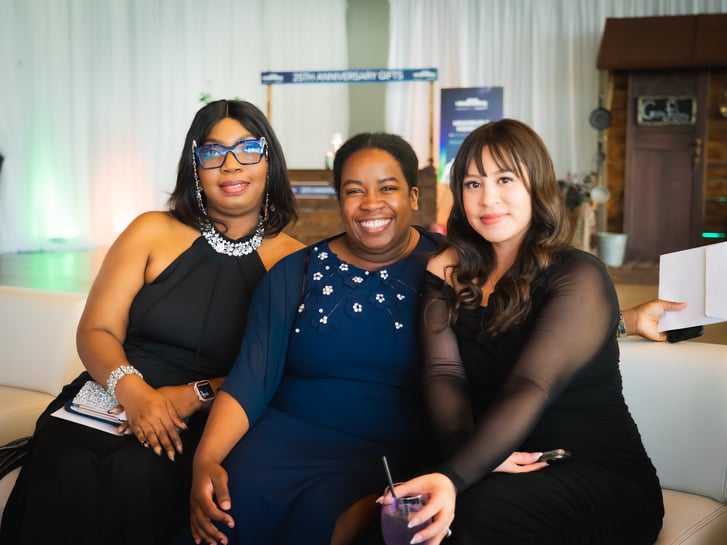 Three Payworks staff seated and smiling in formalwear. 