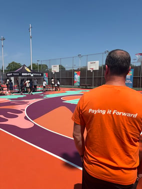 Matt Sachkiw sports a “Paying it Forward” Payworks T-Shirt on the revitalized basketball court at Parc Martin Luther King in Montréal. 