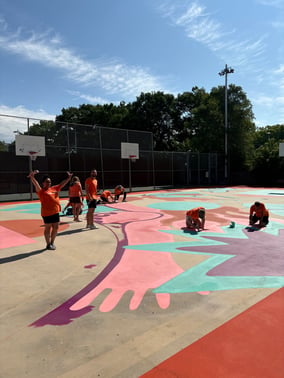 Members of the Payworks Quebec team paint the court mural at Parc Martin Luther King in Montréal.