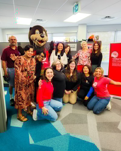 8.	A group of Payworks staff gathered in the office with a seal mascot.