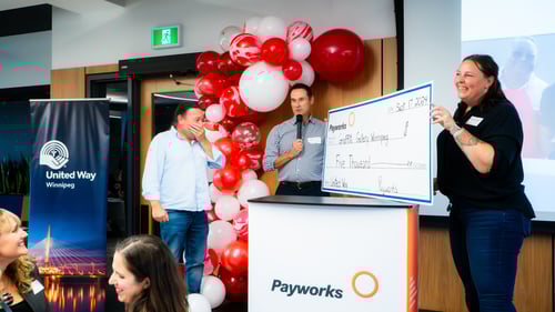 12.	Graffiti Art Programming Executive Director appearing overcome by surprise while accepting an oversized cheque from two Payworks staff.