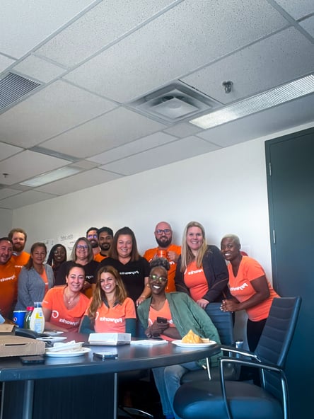 Fourteen Payworks staff gathered around a meeting room table for lunch.