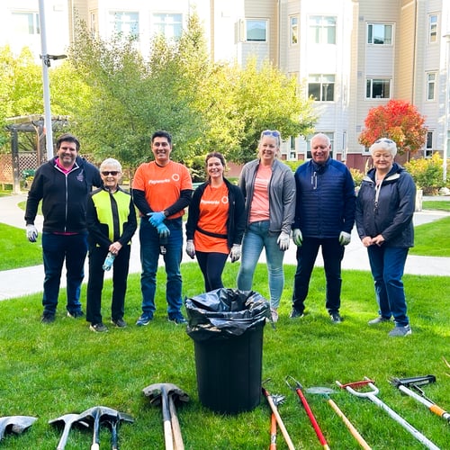 13.	A group of Payworks staff outdoors and surrounded by gardening equipment.