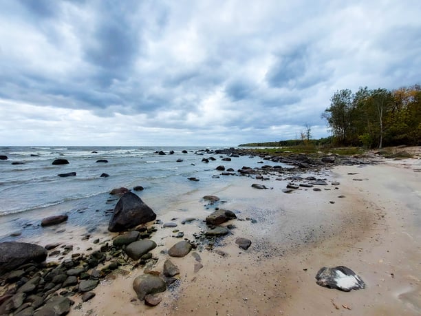 Une plage rocailleuse au bord d’un lac par une journée nuageuse