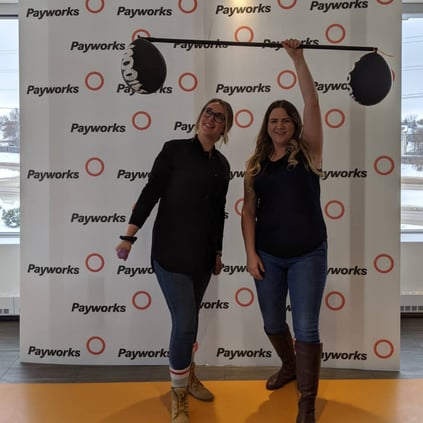 Two individuals in a photo booth holding up weights.