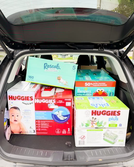 The back of a vehicle packed to the roof with diaper boxes.