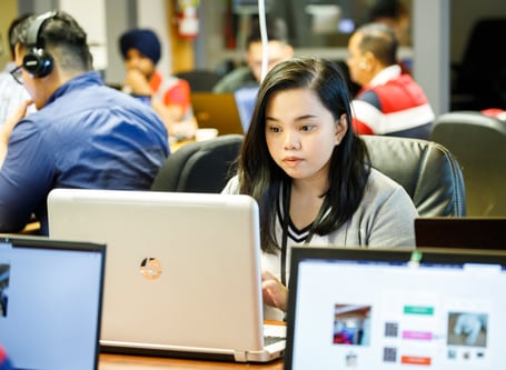 A Red River College student working on a laptop. 