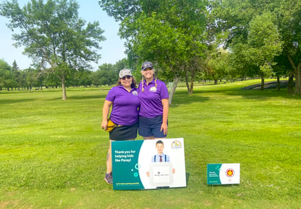 Two Payworks staff at a golf tournament.