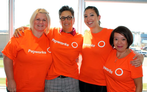 Four individuals in Pay it Forward orange t-shirts.