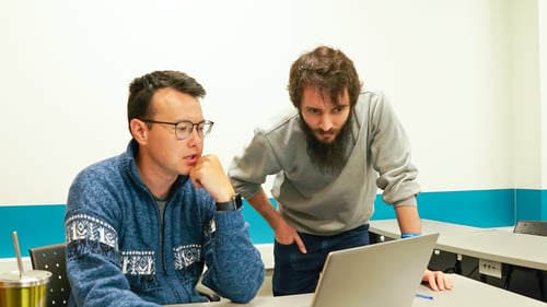 Two Payworks staff looking at a laptop computer in deep thought. 