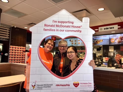 Two Payworks staff with one McDonalds staff member in a photo booth heart.