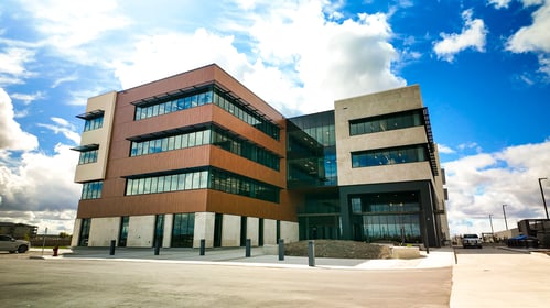 -	Un bâtiment moderne de quatre étages vu de l’extérieur par une journée ensoleillée