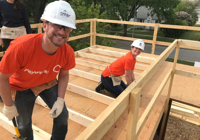 Two Payworks staff building a house.