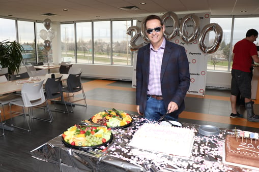 President and CEO JP Perron cutting a cake.