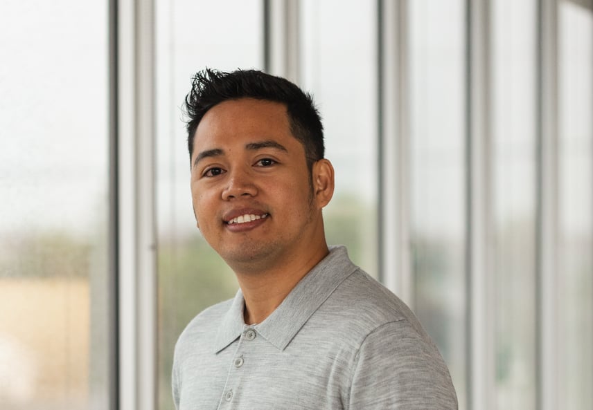 Un membre du personnel de Payworks en chemise grise, près d’une fenêtre