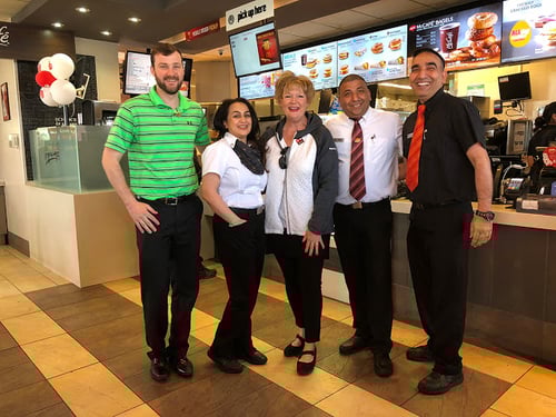 Two Payworks staff members with three McDonald's staff members. 