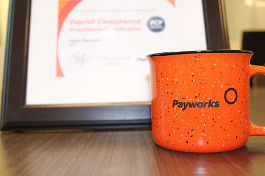 Payworks coffee mug and a framed certificate. 