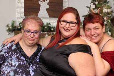 Three individuals at a holiday party. 