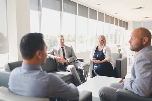 Four people, including article author Trina Huntley, gathered in a sunny office space for an informal meeting.