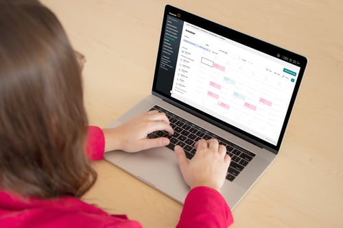 Une femme tape sur un portable, le calendrier de la Gestion du temps est à l’écran. 