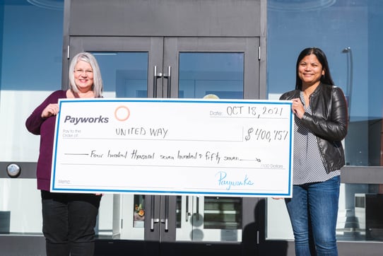 Two Payworks employees holding a cheque for $400,757.