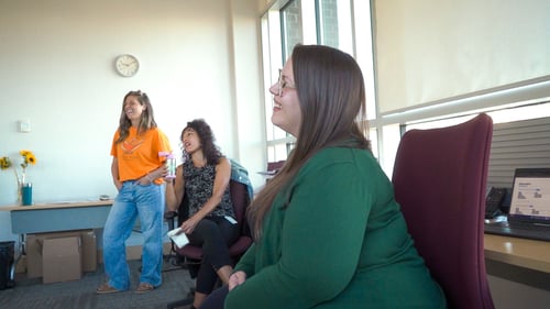 Three United Way Sponsored Campaign Associates laughing together in an office.