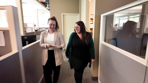 Two United Way Sponsored Campaign Associates walking through an office.