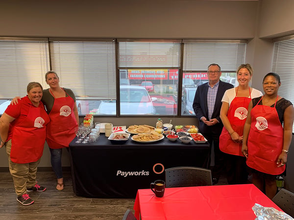 Five Payworks staff members at a breakfast table.