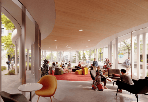 A gathering space with glass walls on three sides and high ceilings, filled with people.
