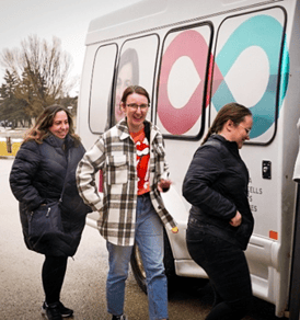 Trois employés de Payworks montent dans un autobus.