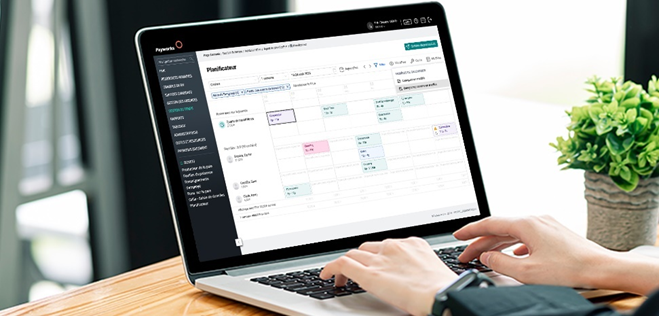 Personne utilisant un modèle de calendrier sur un ordinateur portable pour une planification efficace des horaires.