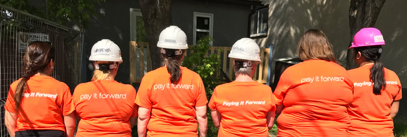 Six Payworks staff wearing t-shirts that say "Pay it Forward". 