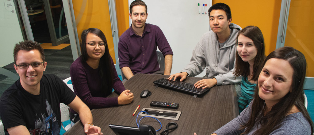 Members of the Payworks team in 2019 sitting around a conference room table. 