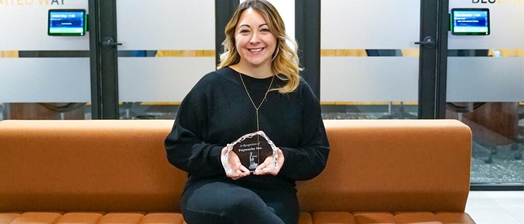 VP of HR holding the Manitoba Top Employer’s award accompanied by text that reads, “Honoured to be recognized as one of Manitoba’s Top Employers”.  