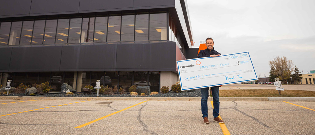 Payworks President and CEO JP Perron holding a cheque for $105,000. 