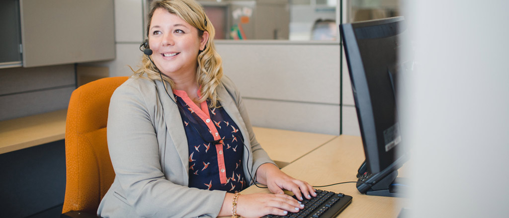 A woman with a headset sitting at a computer. Text reads, “welcome back employees (season or otherwise) in three easy steps”.  