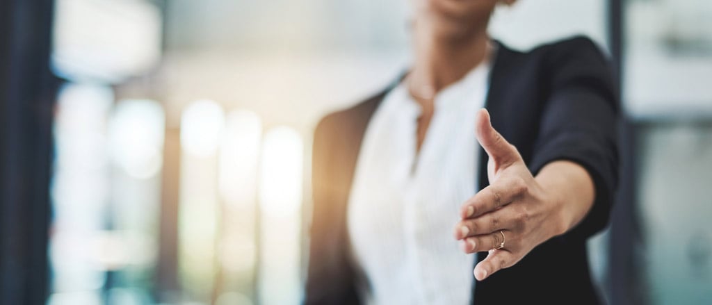 A lady holding out her hand for a handshake. Text reads, “What’s not to love about Applicant Tracking Software?”.  Payworks can help with recruitment.