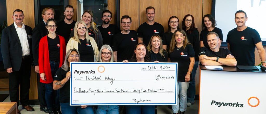 A group photo of Payworks’ United Way committee with a large cheque accompanied by text that reads, “Celebrating the success of this year’s United Way Workplace Campaign”.  