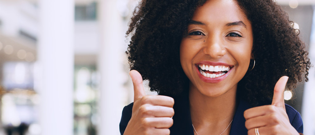 A woman smiling with two thumbs up. Text reads “the importance of recognition in a virtual environment”.  