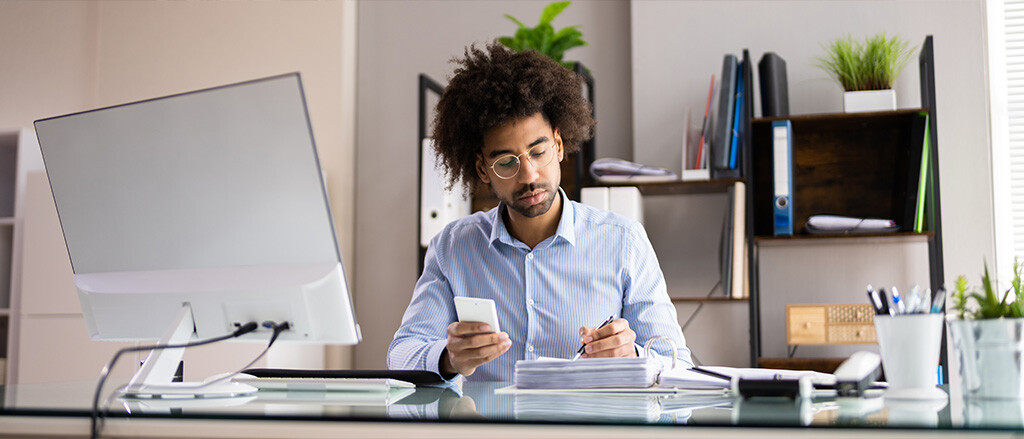 A man writing in his notebook while holding a calculator, accompanied by text that reads "understanding pay in lieu and severance (and how we can help with both!)". 